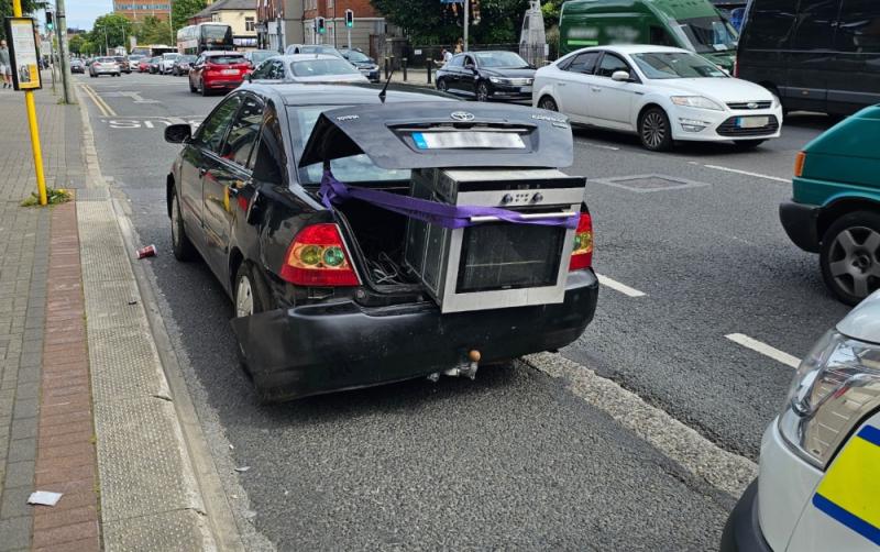 Recipe for disaster: Phone-using driver with oven hanging out of the boot has car seized