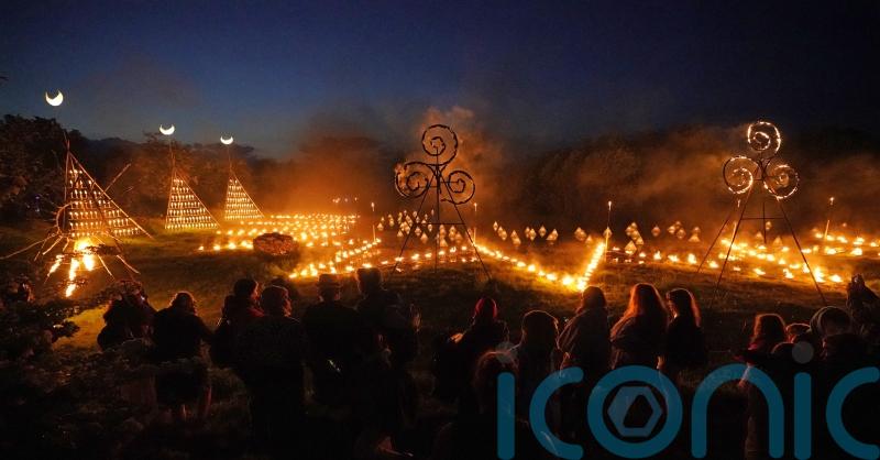 Spectators gather for ancient Celtic fire procession that welcomes summer